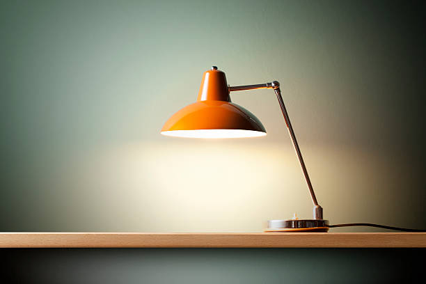 Desk lamp and blinds controlling window light in home office